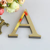 A shaped golden letter wall decal featuring floral accents on a white background.