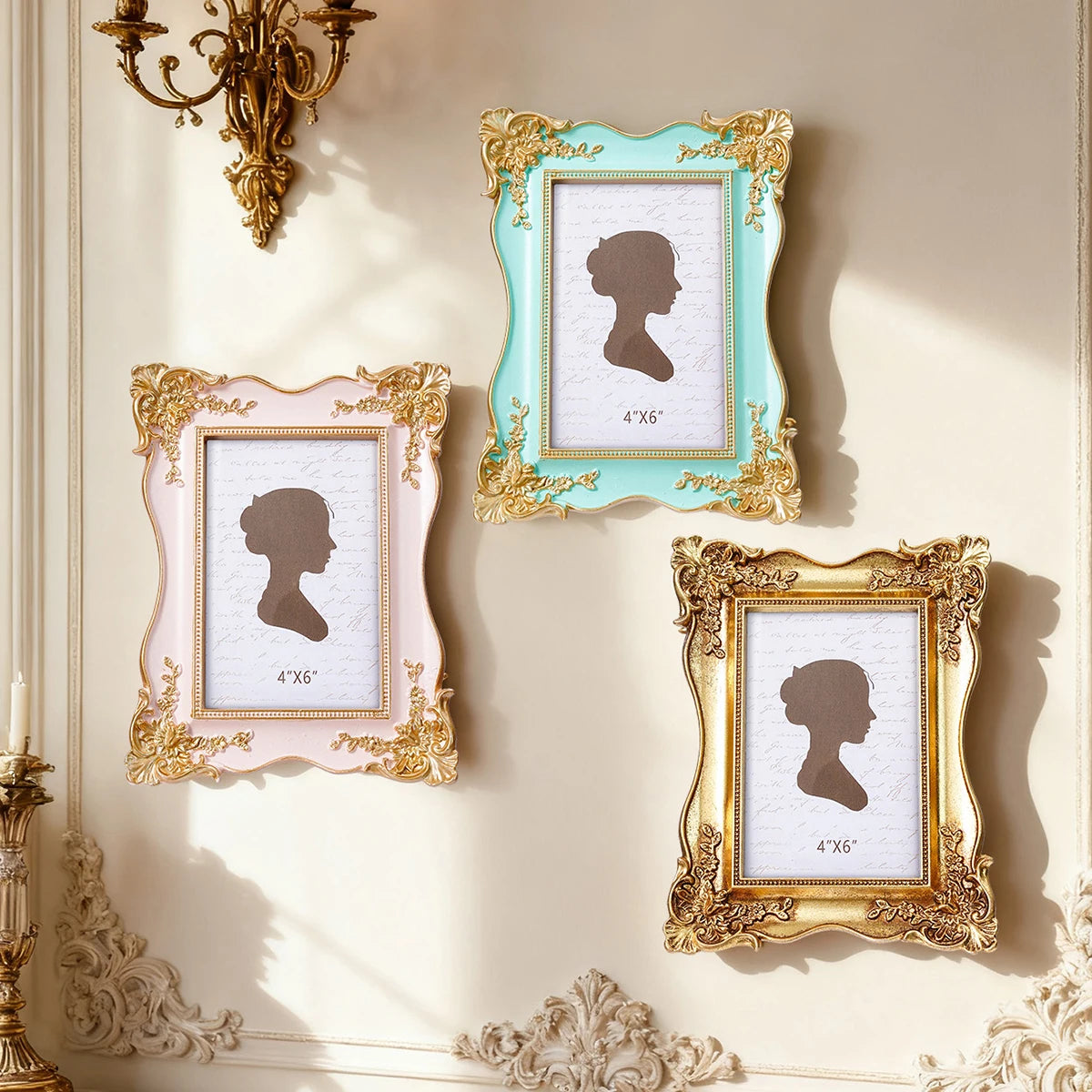 Three ornate gold and pale blue picture frames displaying silhouette portraits on a light wall.