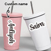 A pink tumbler with a custom name sticker reading Aniyah and a white tumbler with a custom name sticker reading Saira.