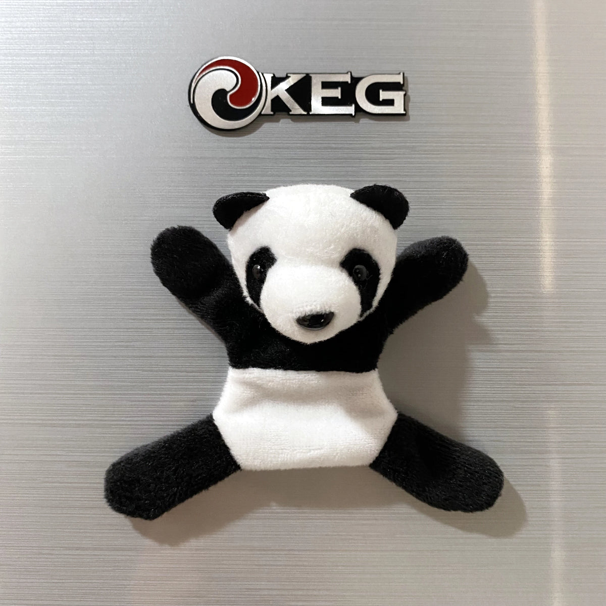 A fridge magnet featuring a cute panda design with black and white fur.