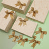 Pink textured gift boxes with gold satin ribbon bows for wrapping and decor