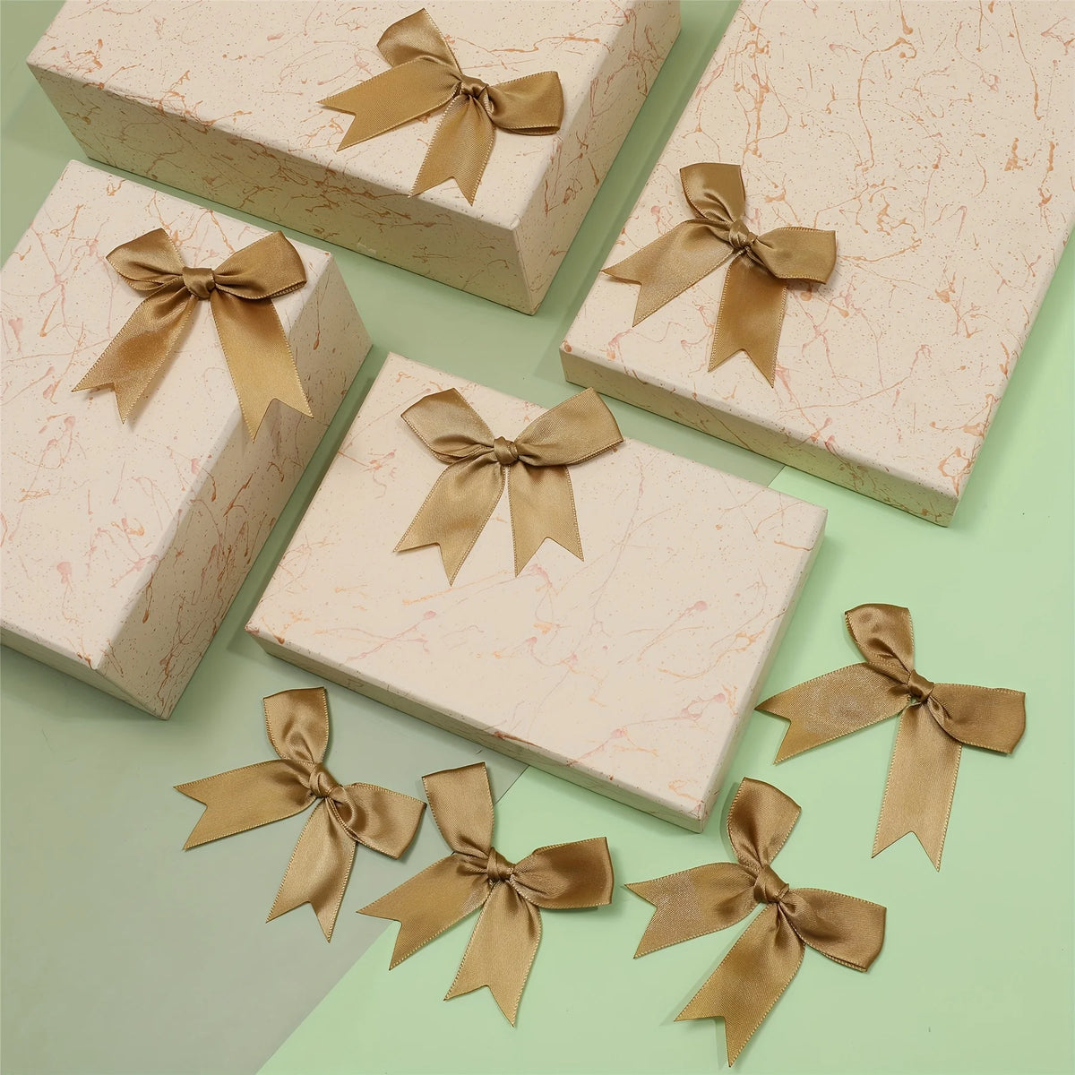 Pink textured gift boxes with gold satin ribbon bows for wrapping and decor