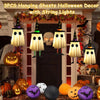 Three hanging ghost decorations with witch hats and string lights displayed in a Halloween decor setting.