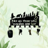 Black metal wall-mounted key holder with seven hooks displayed against a light green watercolor background.
