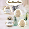 A handmade knitted plush potato doll with a stitched face and expression.