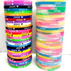 A stack of colorful silicone bracelets featuring a Jesus heart design in various shades of pink, yellow, blue, and green.