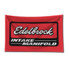A red racing car garage flag featuring the Edelbrock intake manifold logo in black and white.