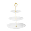 A gold-colored three-tier plastic cupcake stand with white plates and a decorative golden fork.