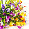 A bouquet of artificial purple and yellow calla lilies with green stems for home decor