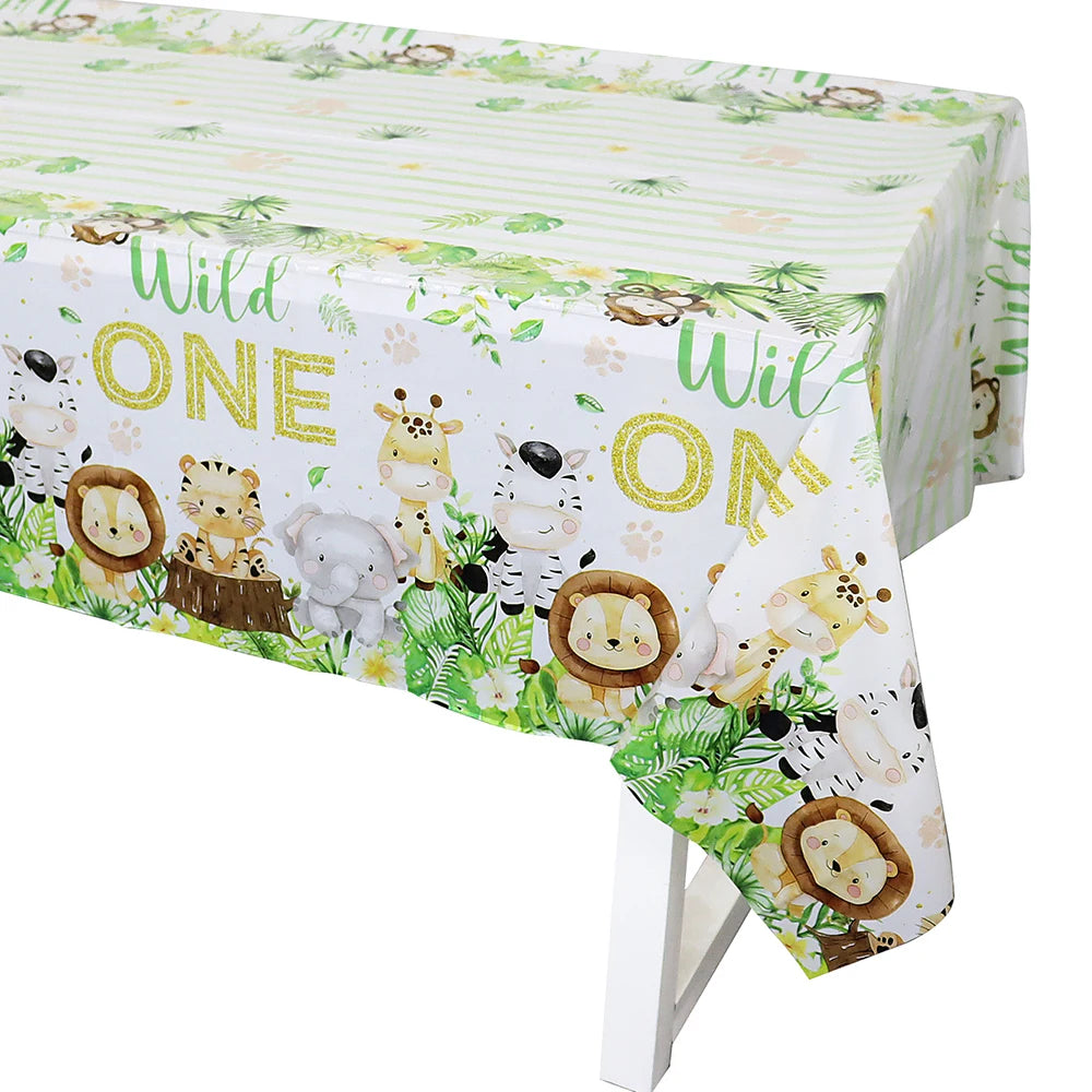 A white tablecloth decorated with a Wild One jungle safari theme featuring various cute animal illustrations.