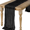 Black semi-sheer gauze table runner draped over a wooden table.