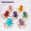A collection of colorful crystal octopus statues in various shades including pink, orange, purple, green, and blue.