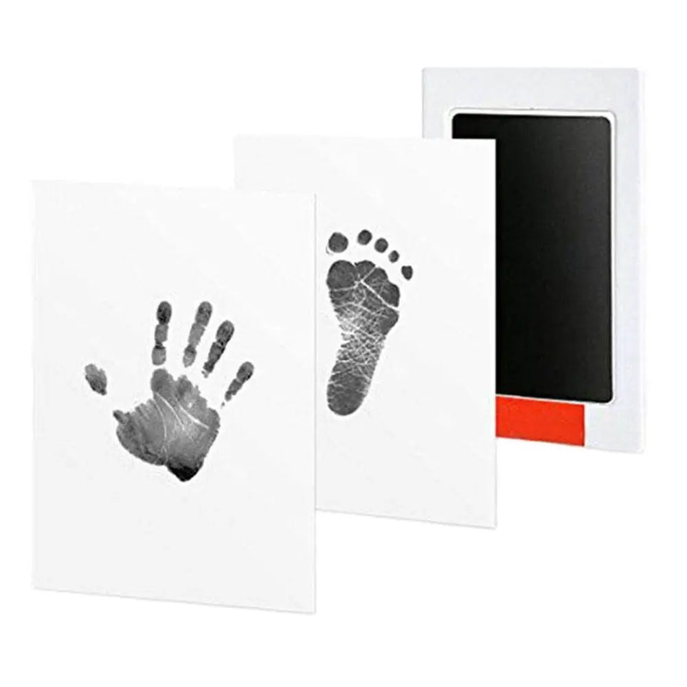 A white card featuring a handprint and footprint impression, next to a black photo frame.