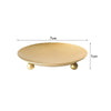 A round, shallow tray or holder with a gold finish and small gold accents, measuring 7cm in diameter.