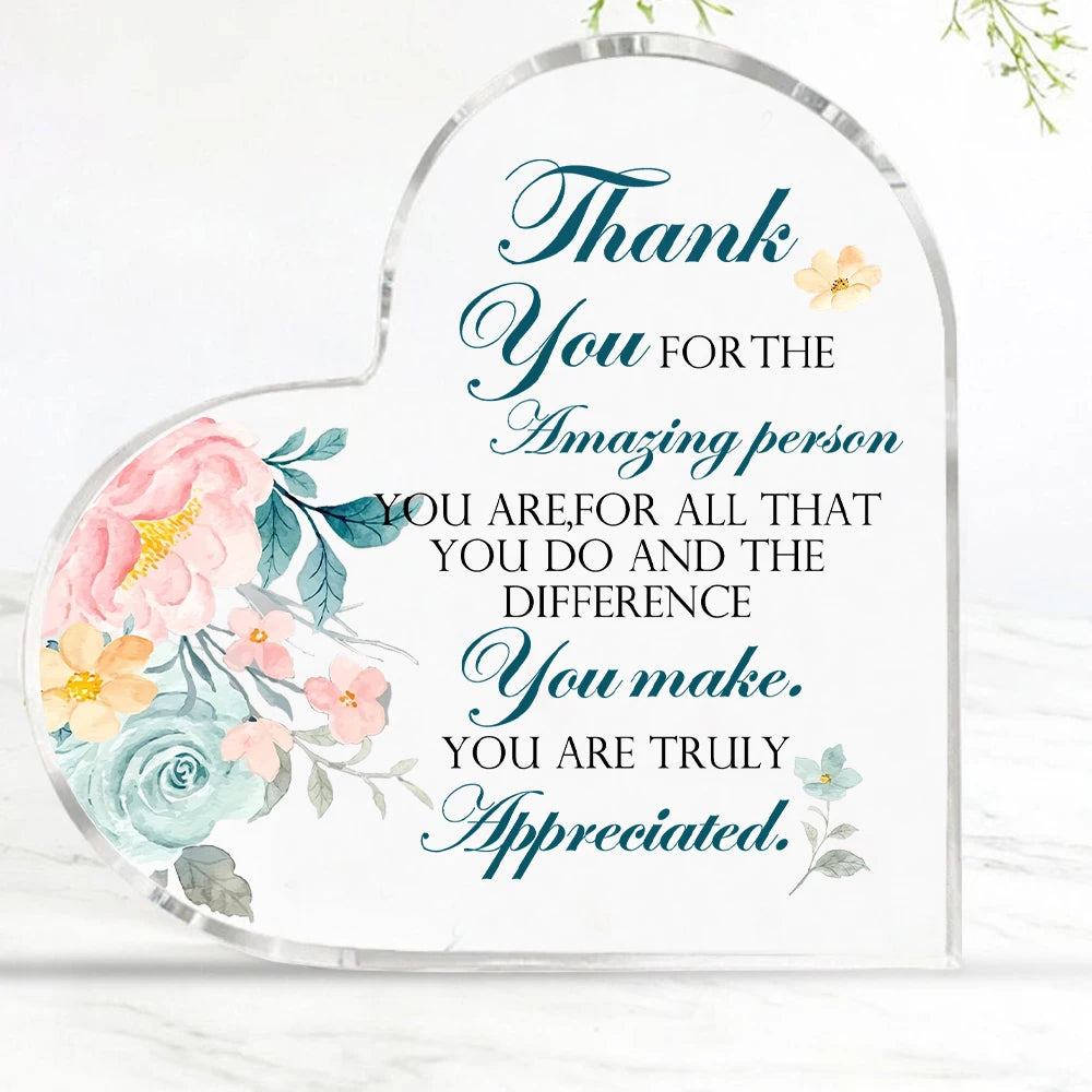 A clear acrylic heart-shaped sign with blue script text that reads Thank You for the amazing person you are for all that you 