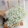 A bouquet of white artificial baby's breath flowers displayed in a wooden box.