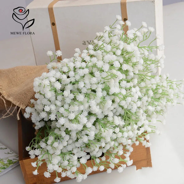 A bouquet of white artificial baby's breath flowers displayed in a wooden box.