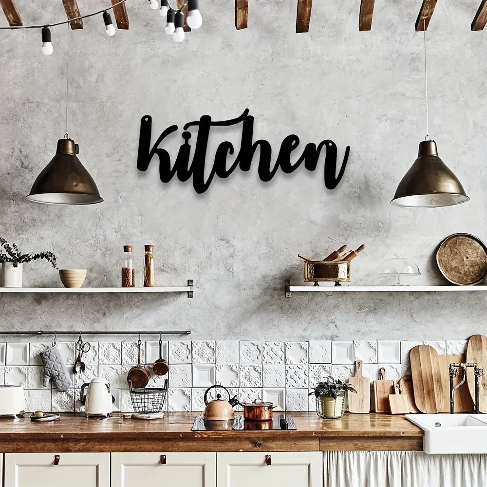 Minimalist metal letter wall art spelling the word kitchen on a gray concrete wall with rustic wooden shelves and lighting.