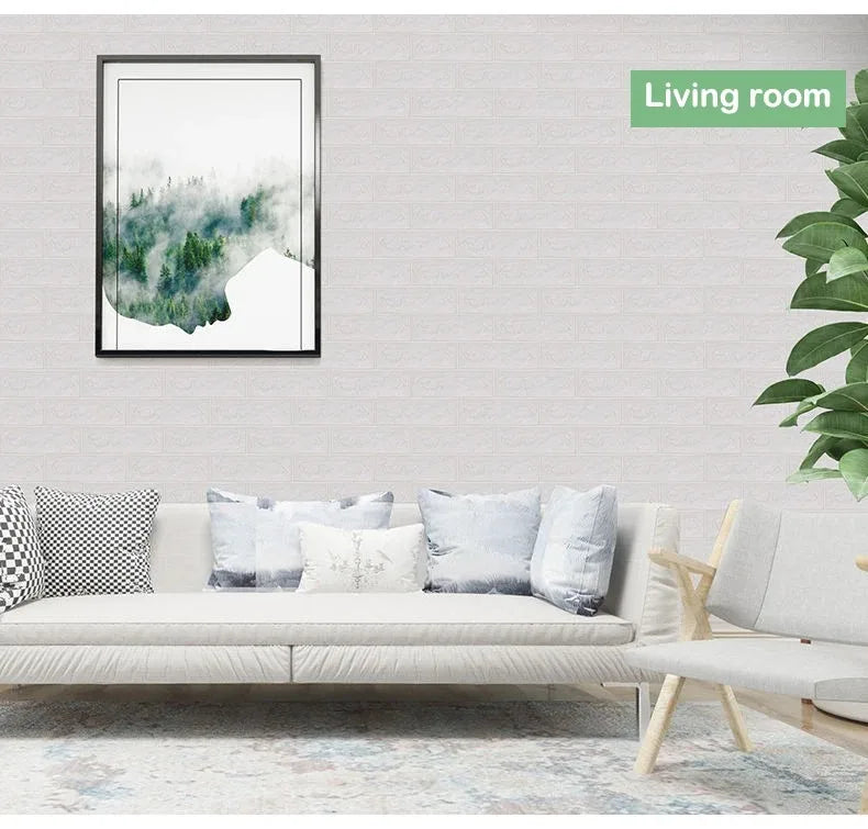 A living room interior featuring a sofa with light cushions and a framed watercolor painting of misty green landscape.