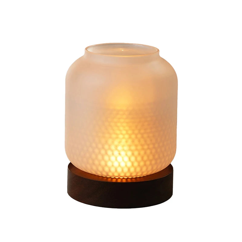 A vintage wooden candle lantern with a glass cover emits a warm, glowing light.