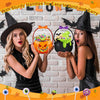 A woman holds an orange Halloween trick or treat candy bag with a handle, set against a brick background.