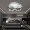 A modern bedroom featuring a bed with a Halloween LED projection lamp resting on the mattress.