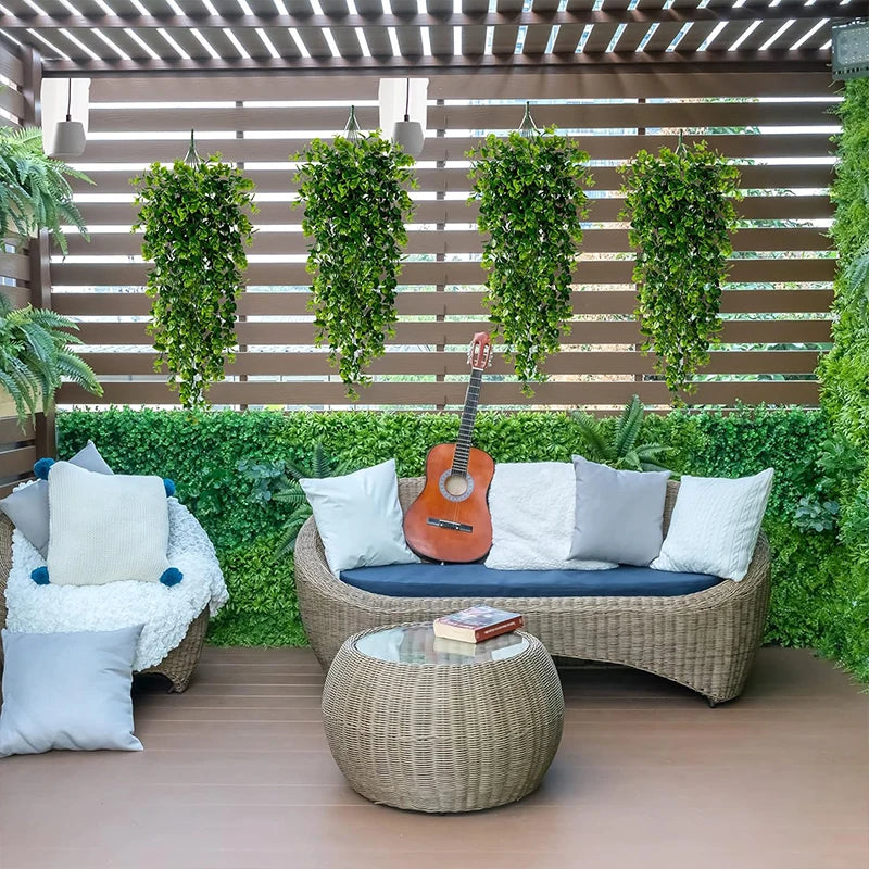 Artificial eucalyptus hanging plants displayed in a wooden patio setting with outdoor furniture.