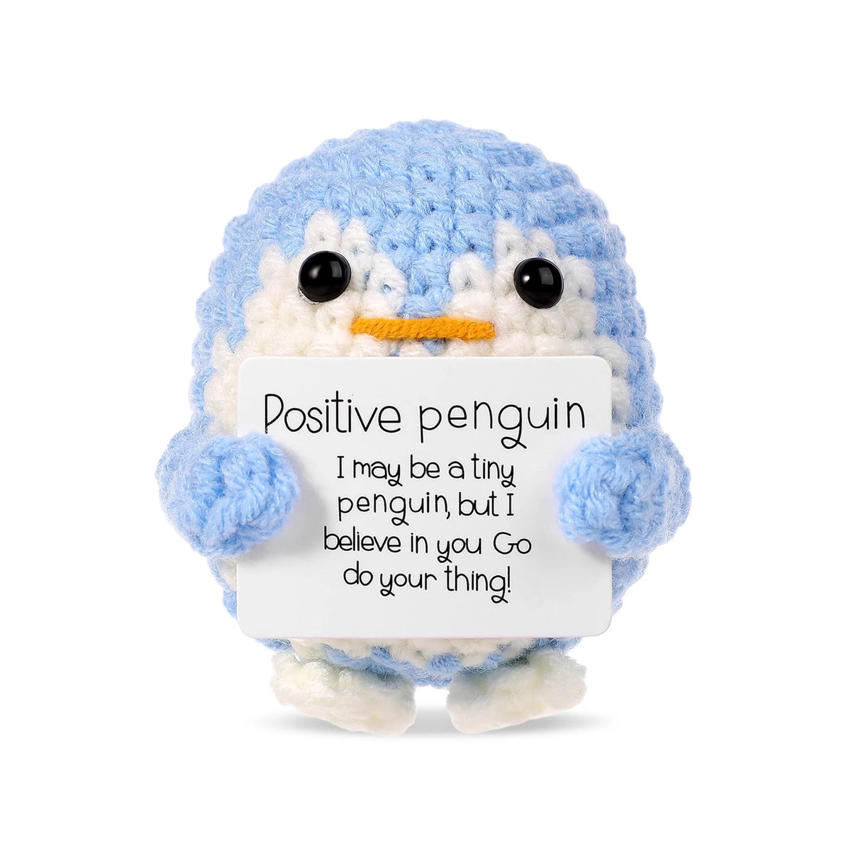 A light blue crocheted penguin plush holding a white card with an encouraging message.