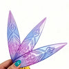 A hand holds a purple and blue Lumi Symbol Sword cosplay prop with intricate floral patterns.