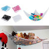 A kids' corner toy hammock made of mesh fabric is shown with various stuffed animals and toys stored inside.