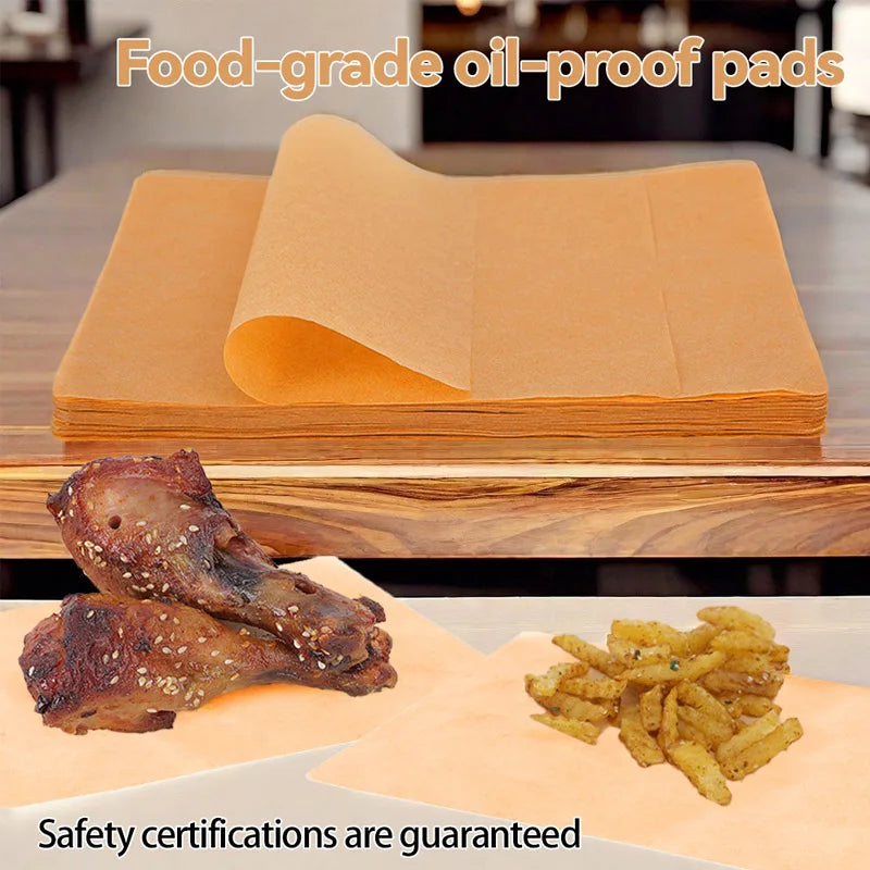 Food-grade oil-proof pads stacked on a wooden surface with cooked poultry and fried food nearby.