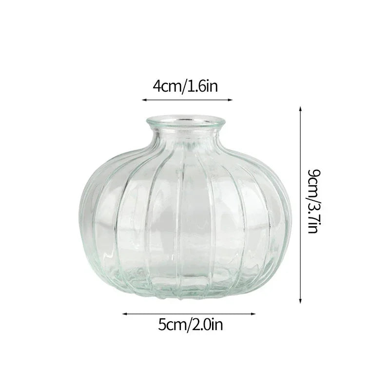 Modern clear glass vase with a rounded body and narrow neck, measuring 9cm high and 5cm wide.