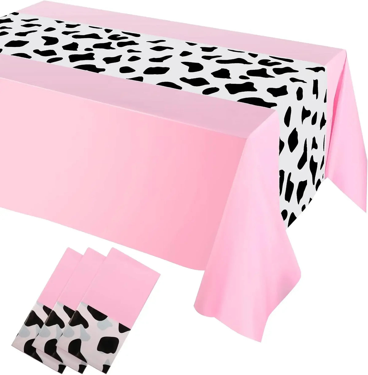 Pink cow print western tablecloth with a black and white spotted pattern displayed on a table.