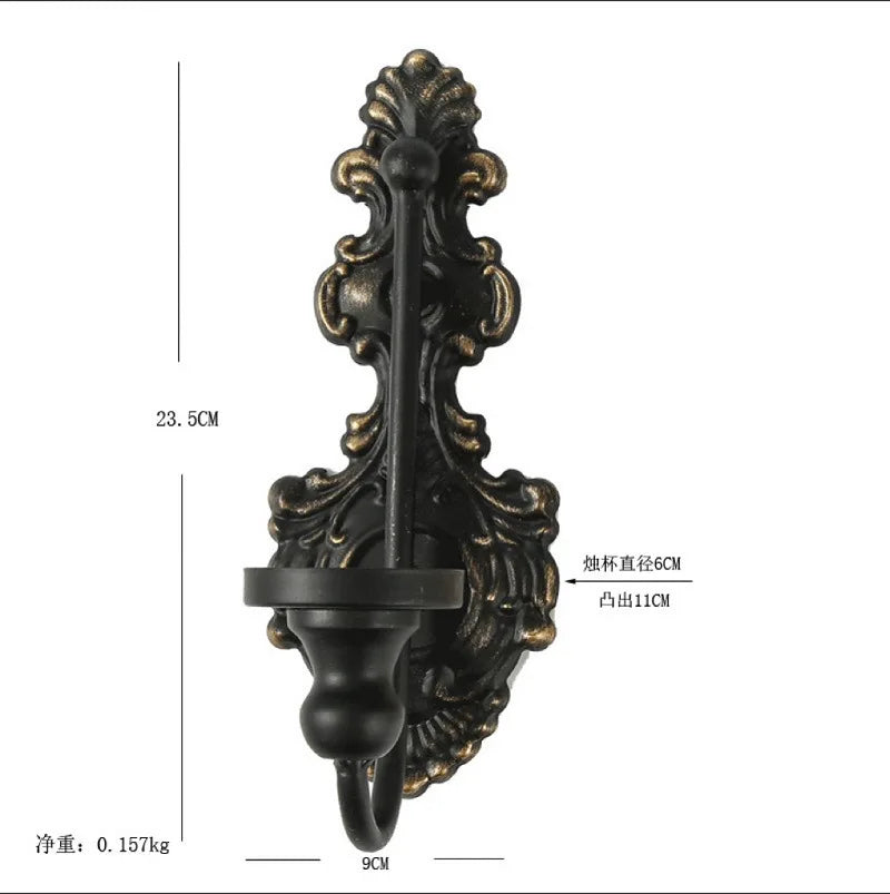Vintage black wall-mounted double candle holder with ornate scrollwork and a hanging loop