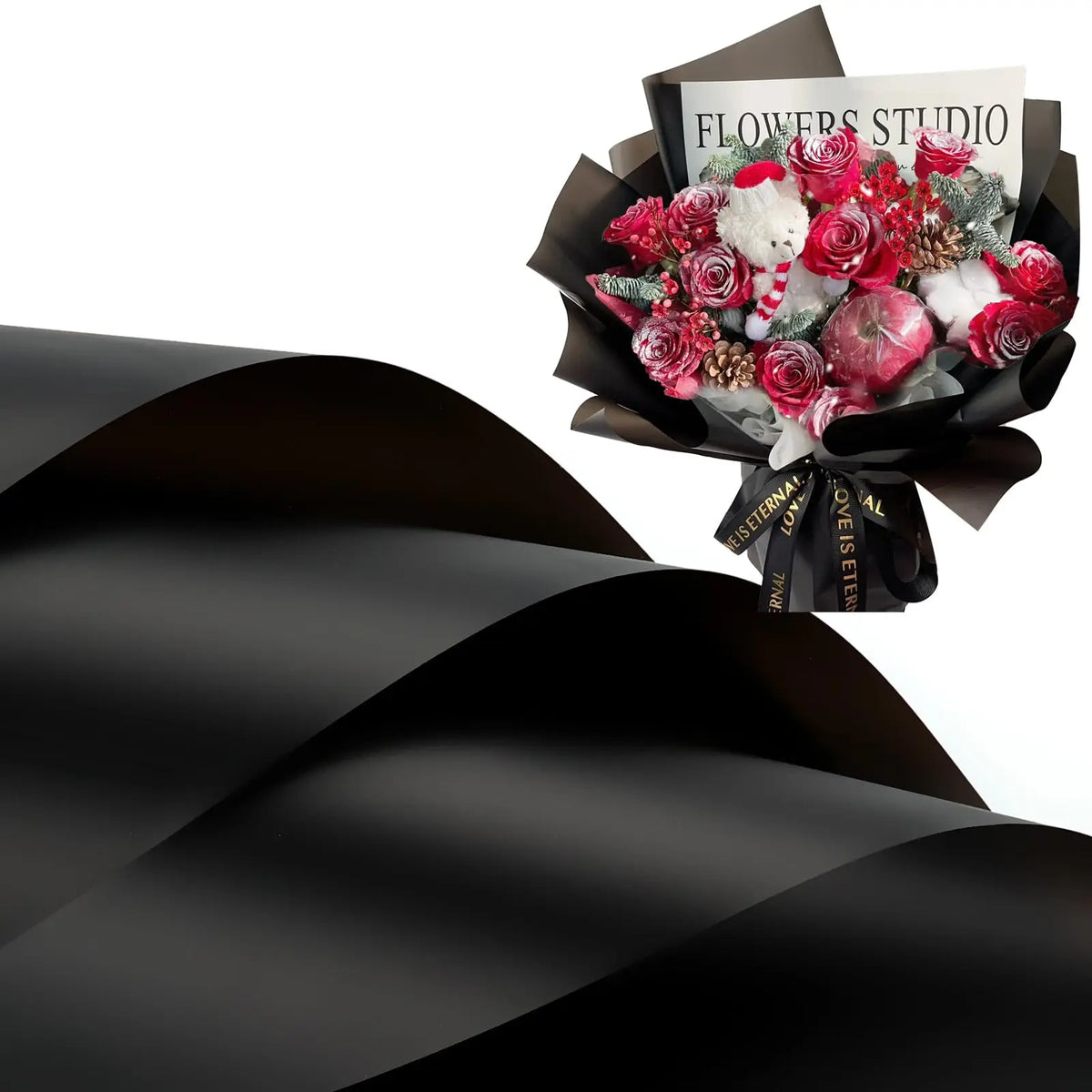 A bouquet of red and white flowers wrapped in black paper with a sign reading Flowers Studio