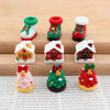 A set of festive Christmas resin decor featuring miniature houses and ornaments in red, green, and white.