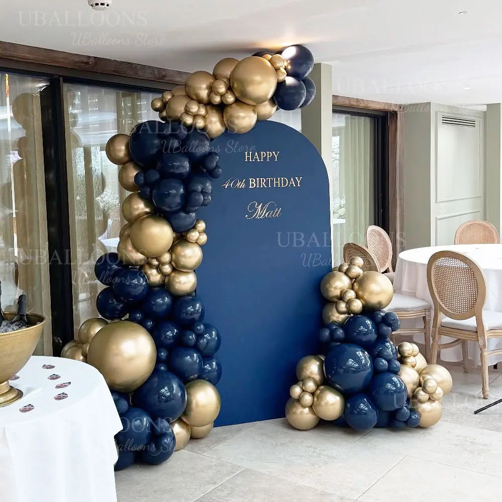 A balloon garland featuring metallic gold and navy blue balloons decorating a party backdrop.