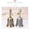 Pair of ornate brass hand call bells with decorative floral patterns