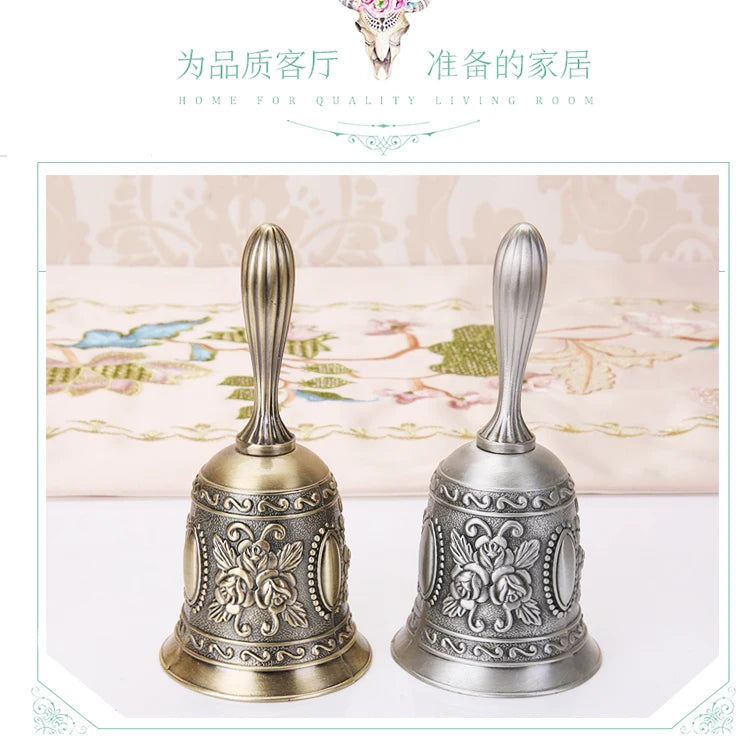 Pair of ornate brass hand call bells with decorative floral patterns