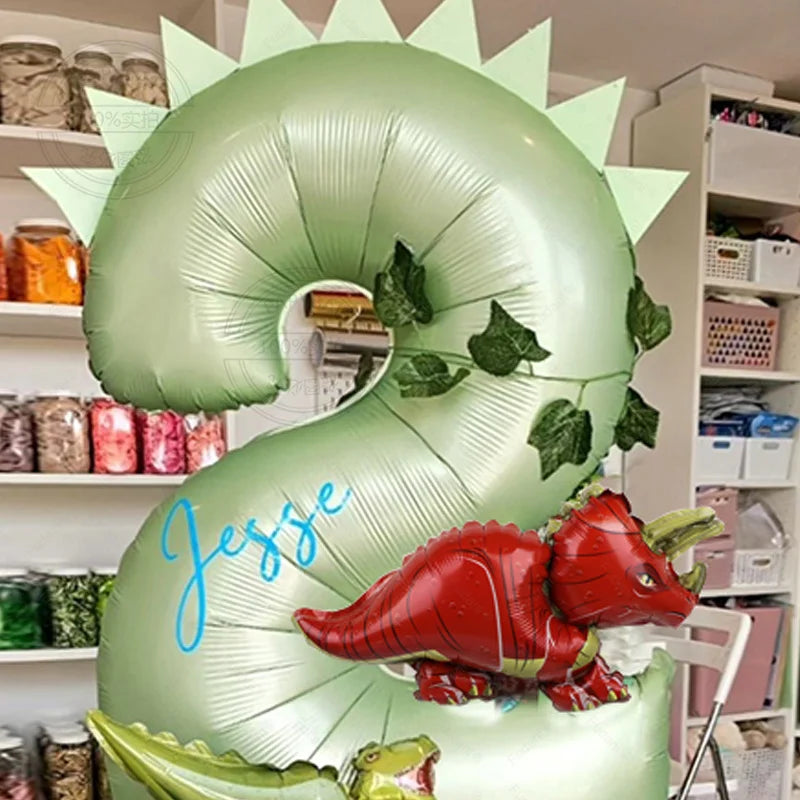 Ein großes grünes Ballon in Form der Ziffer 2 mit einer roten Dinosaurierfigur.