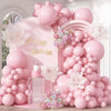 A large arrangement of pastel pink latex balloons and floral accents for a birthday party display.