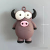 A small, round, gray plastic figure resembling a bull or ox with large white eyes and black horns.