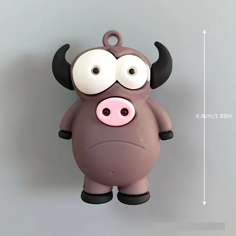 A small, round, gray plastic figure resembling a bull or ox with large white eyes and black horns.