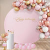 A pink and gold balloon arch backdrop with a large text banner that reads Happy Halloween