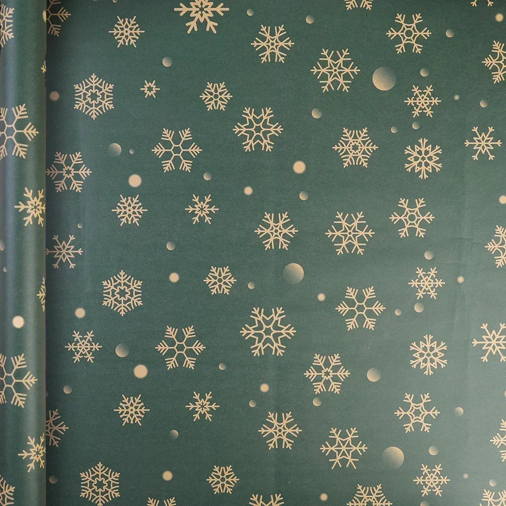 Roll of festive Christmas kraft wrapping paper featuring gold snowflake patterns on a dark green background.