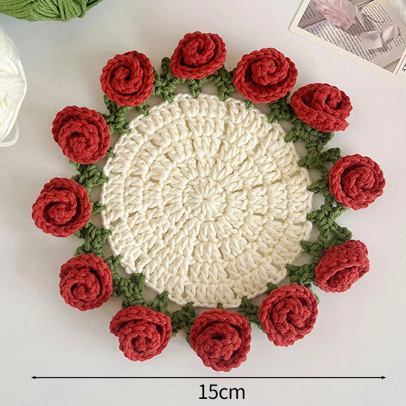 Hand-crocheted rose flower coasters featuring red and green yarn arranged in a circular pattern.