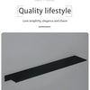 A sleek, modern matte black wall shelf or tray shown lying flat on a light gray surface.