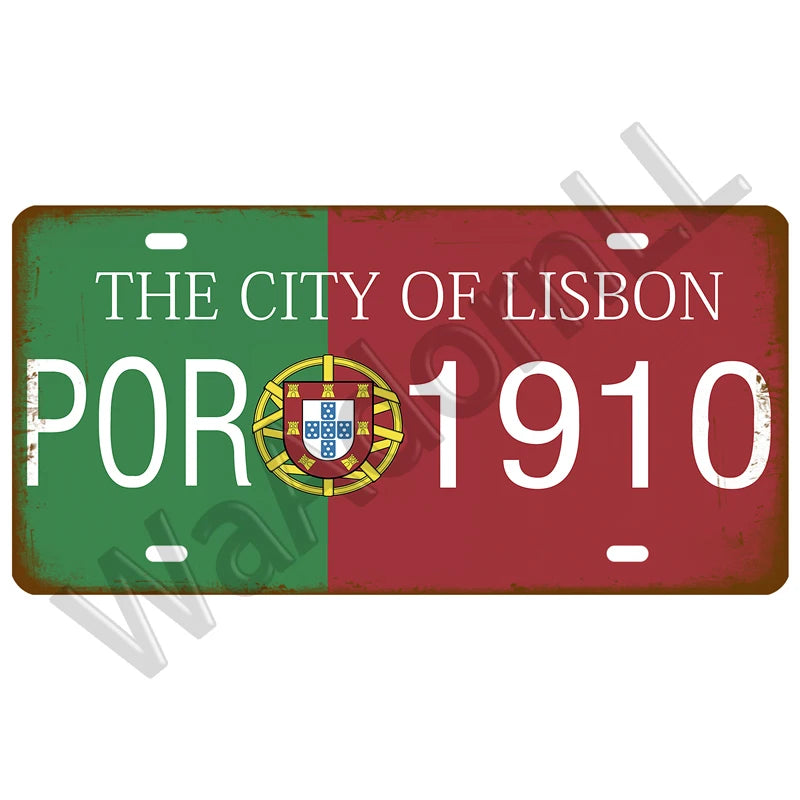 A vintage metal tin sign featuring the text THE CITY OF LISBON and the year 1910 on a green and red background with a coat of