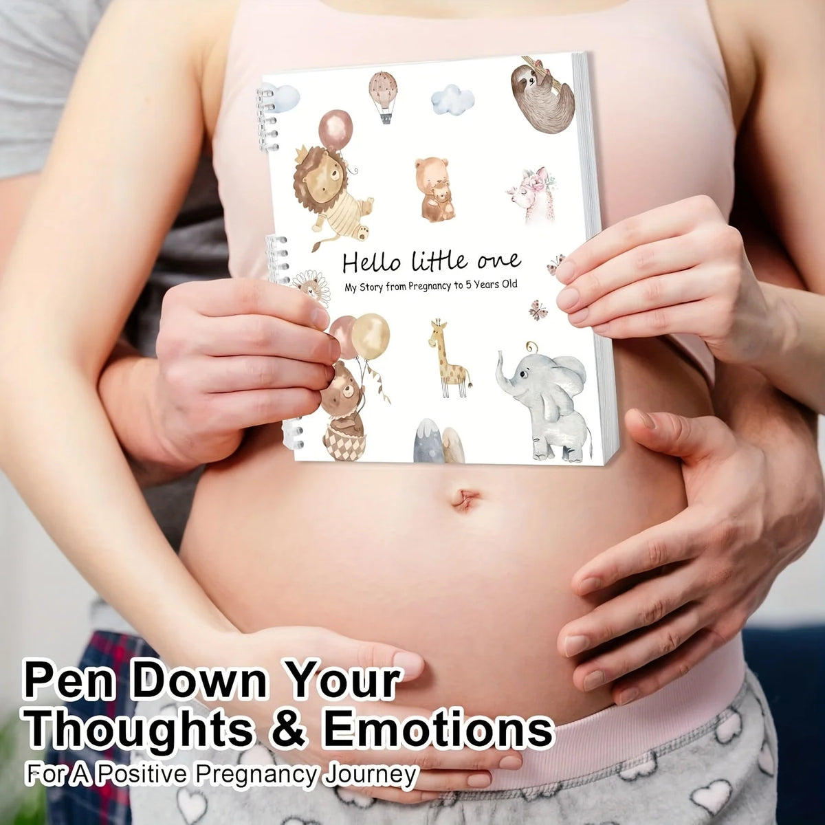A pink maternity belly holds a notebook titled Hello little one featuring cute animal illustrations for a pregnancy journey.