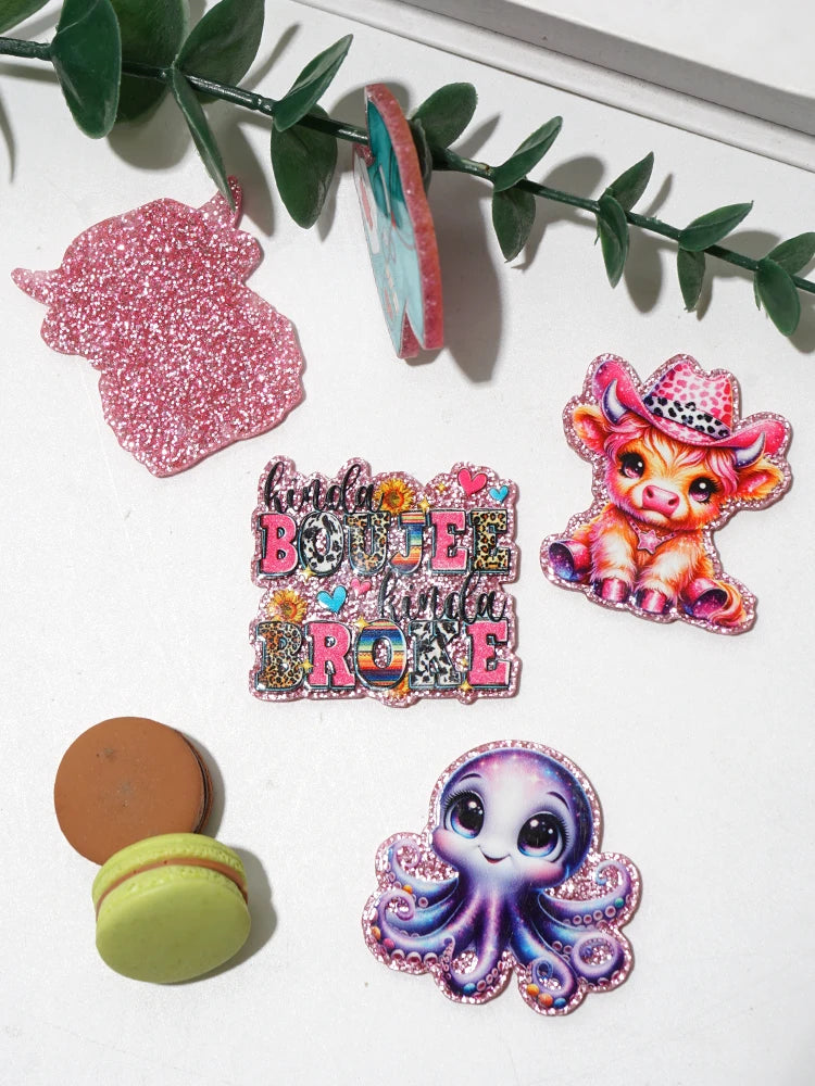 Pink glitter acrylic charms featuring a bunny, a cowboy hat, and a purple octopus for DIY crafts